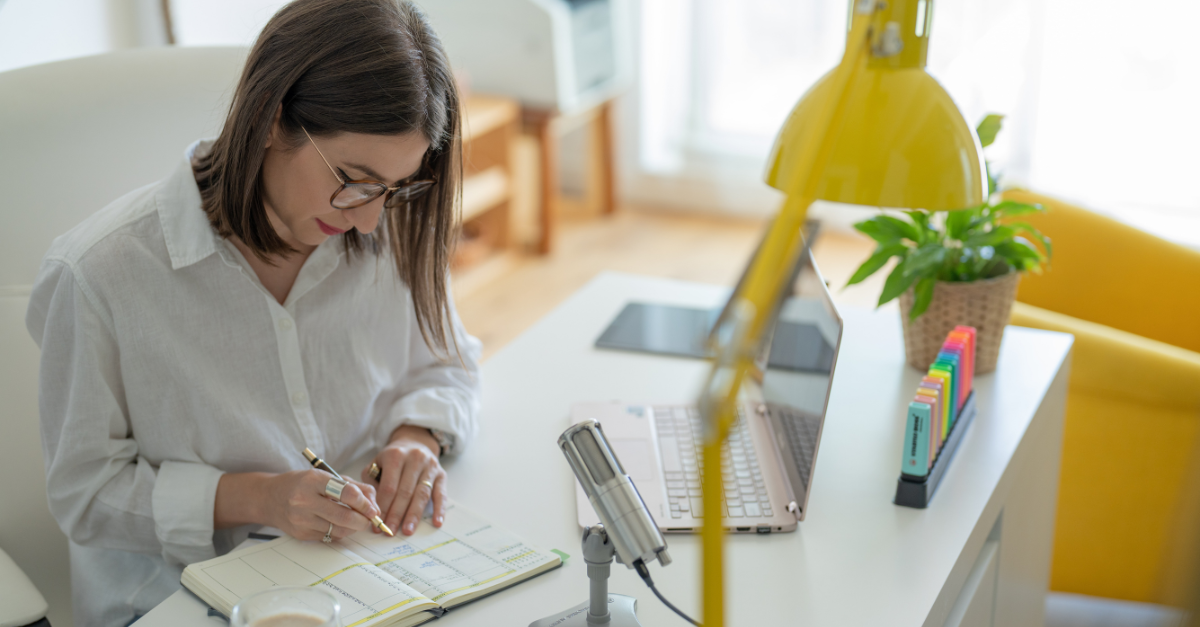 woman writing in journal at desk